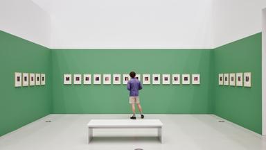 In eienm Ausstellungsraum schaut ein Mann sich Fotografien an, die an einer grünen Wand hängen.