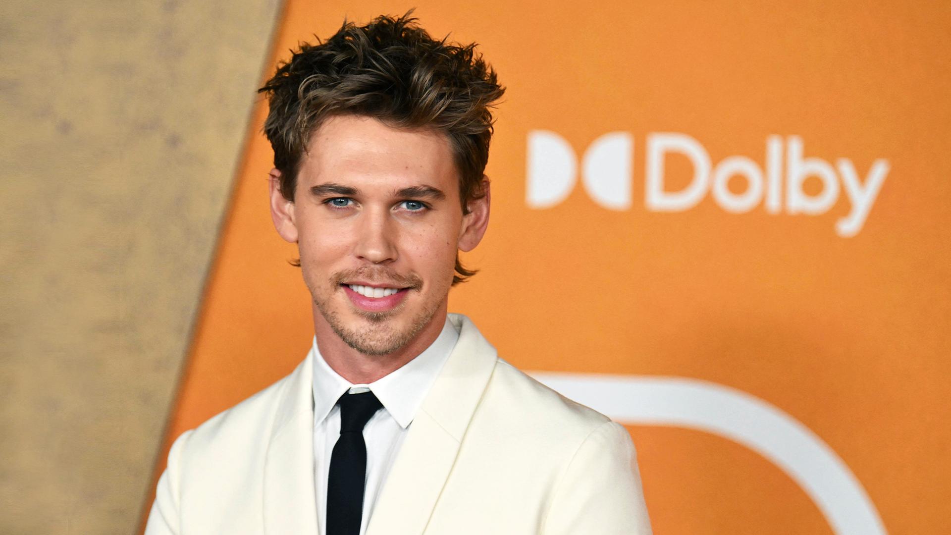Ein Potrait von Austin Butler vor orangenem Hintergrund