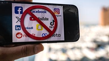 Auf diesem am 18. Juni 2026 in Dubai aufgenommenen Symbolfoto zeigt ein Mobiltelefon die Logos von Social-Media-Plattformen zusammen mit einem Verbotszeichen. Die Vereinigten Arabischen Emirate kündigten ein Social-Media-Verbot für Kinder unter 15 Jahren an.