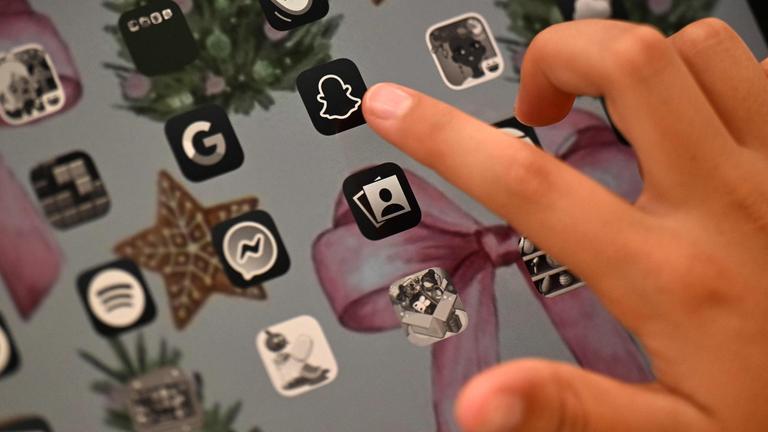 Eine hand zeigt auf das Icon der Social-Media-App Snapchat auf einem Tablet.