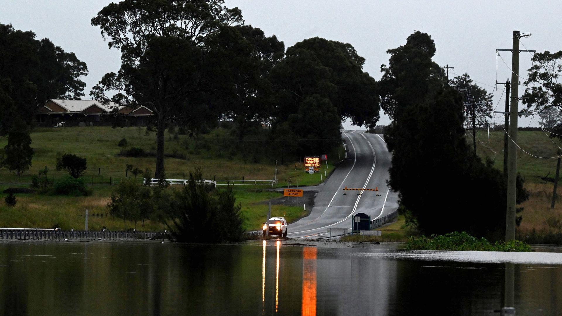 Am 22. Mai 2025 wird eine Straße in Gillieston Heights in der Nähe der Stadt Maitland in New South Wales durch den über die Ufer getretenen Wallis Creek überflutet. 