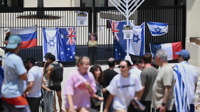 Menschen besuchen am Freitag, den 19. Dezember 2025, eine Blumengedenkstätte vor dem Bondi Pavilion in Sydney nach der Schießerei am vergangenen Sonntag am Bondi Beach.