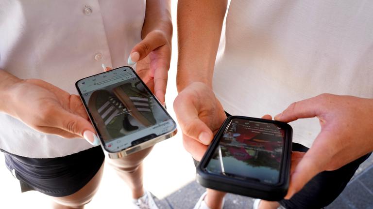 Der 14-jährige Henry (rechts) und Angel (15) nutzen ihre Telefone, um soziale Medien in Sydney anzusehen