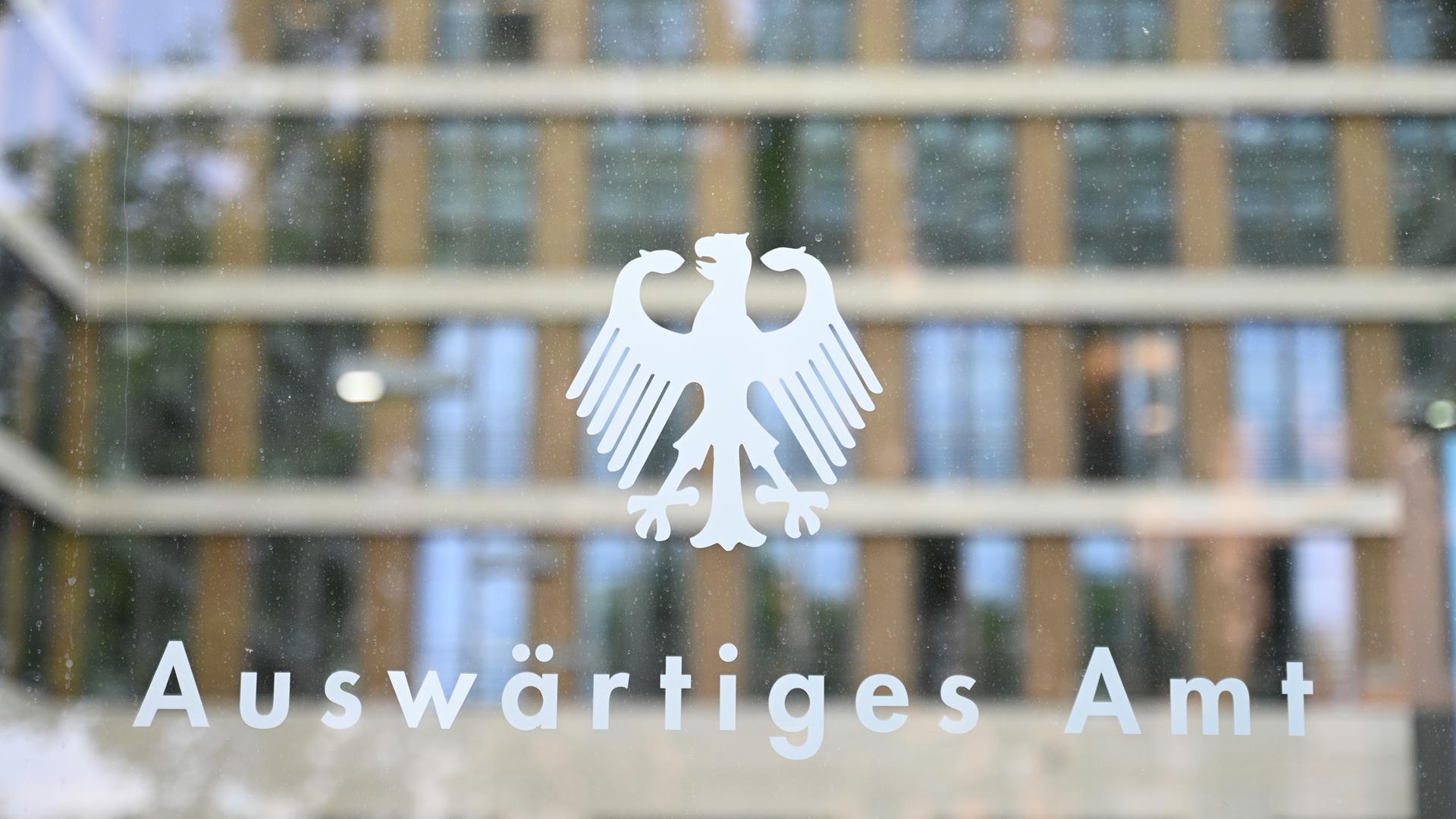 27.05.2025, Berlin: Der Bundesadler und der Schriftzug «Auswärtiges Amt» sind an einer Glasscheibe an einem Eingang zum Auswärtigen Amt zu sehen.