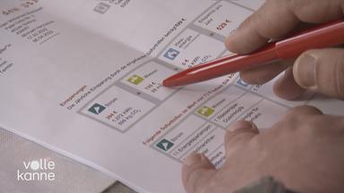 Jemand zeigt mit einem Stift auf eine ausgedruckte Tabelle.