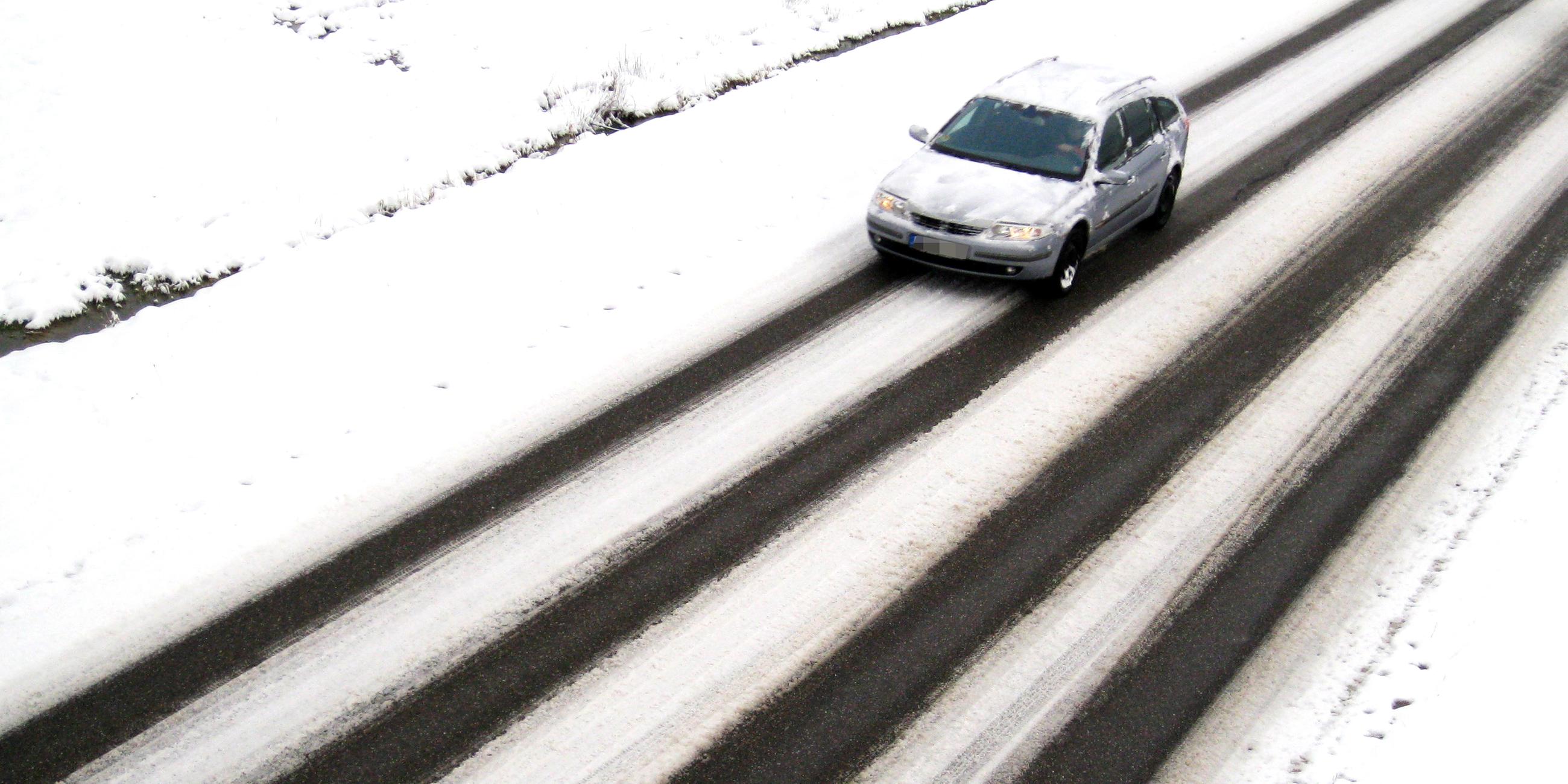 Auto auf verschneiter Landstraße