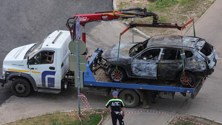 Ein russischer Polizeibeamter beaufsichtigt die Bergung des Fahrzeugs vom Explosionsort nahe einem Wohngebäude in Balaschicha bei Moskau
