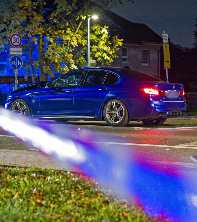 Ein BMW steht in der Nacht an einer Einsatzstelle in der Region Hannover. Einsatzkräfte haben zuvor auf ein Auto geschossen, dass zuvor in eine Gruppe von Menschen gefahren ist