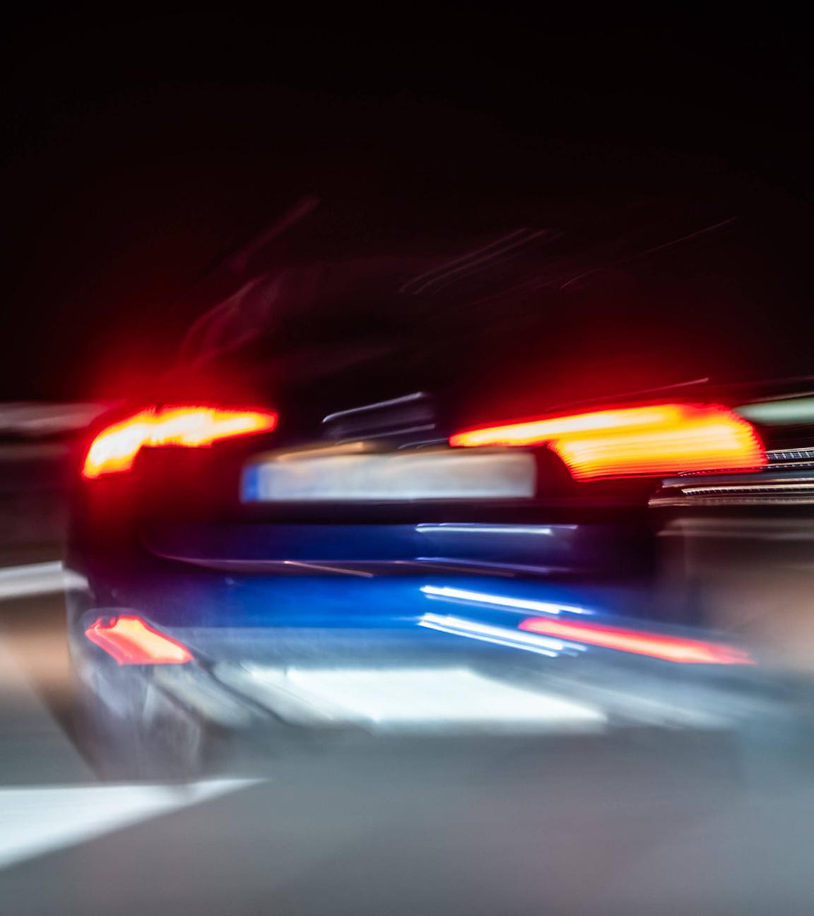 Auto fährt bei Nacht über eine Autobahn. 