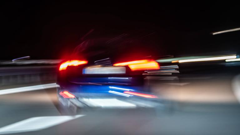 Auto fährt bei Nacht über eine Autobahn. 