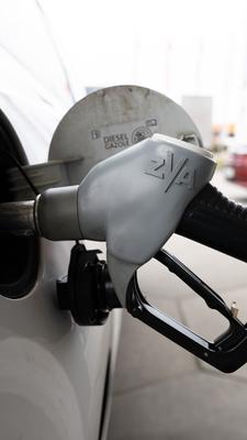Ein Tankstutzen steckt an einer Tankstelle in der Tanköffnung eines Fahrzeugs.