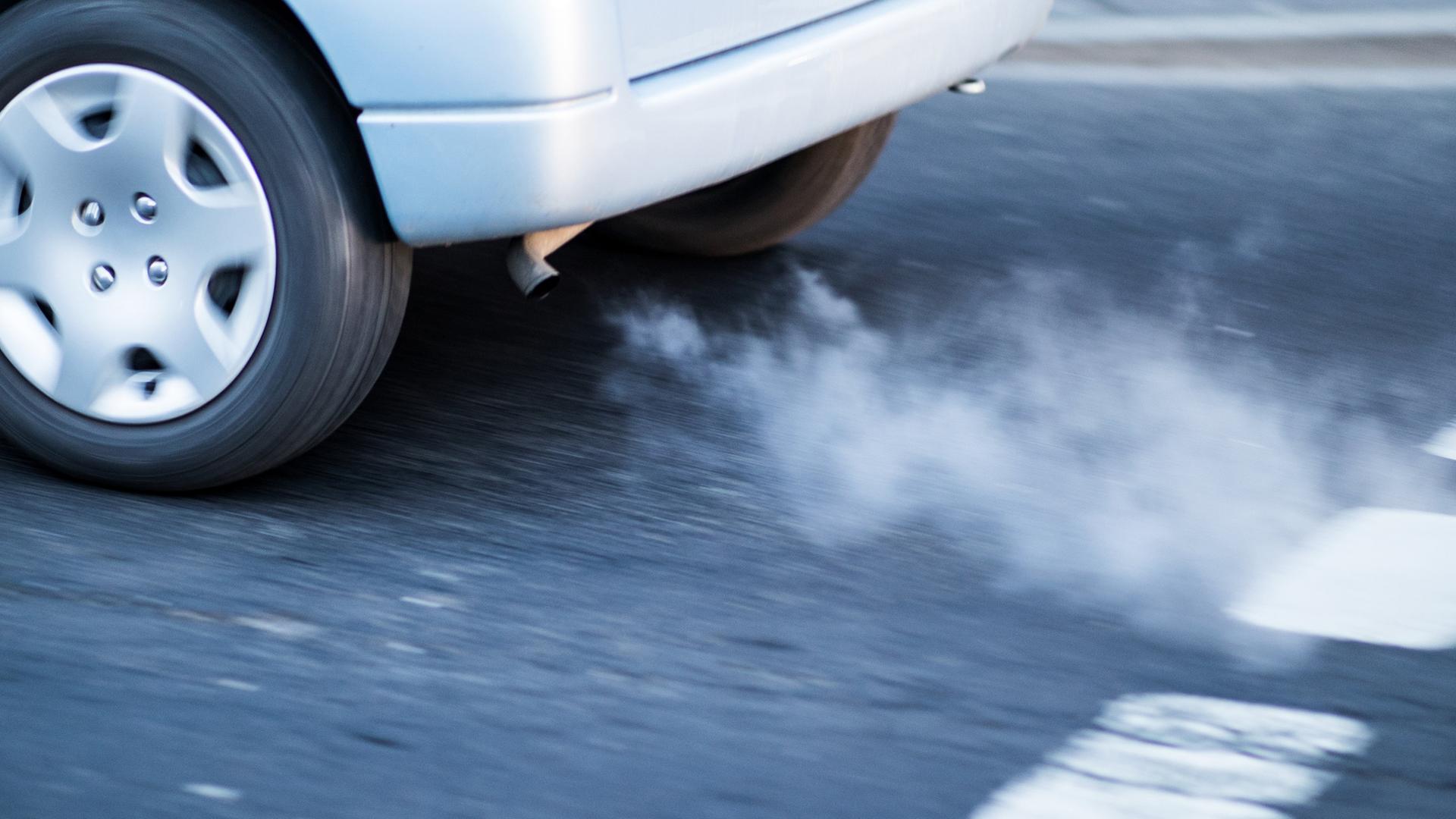 Symbolbild: Abgas kommt aus dem Auspuff eines Autos im morgendlichen Berufsverkehr 