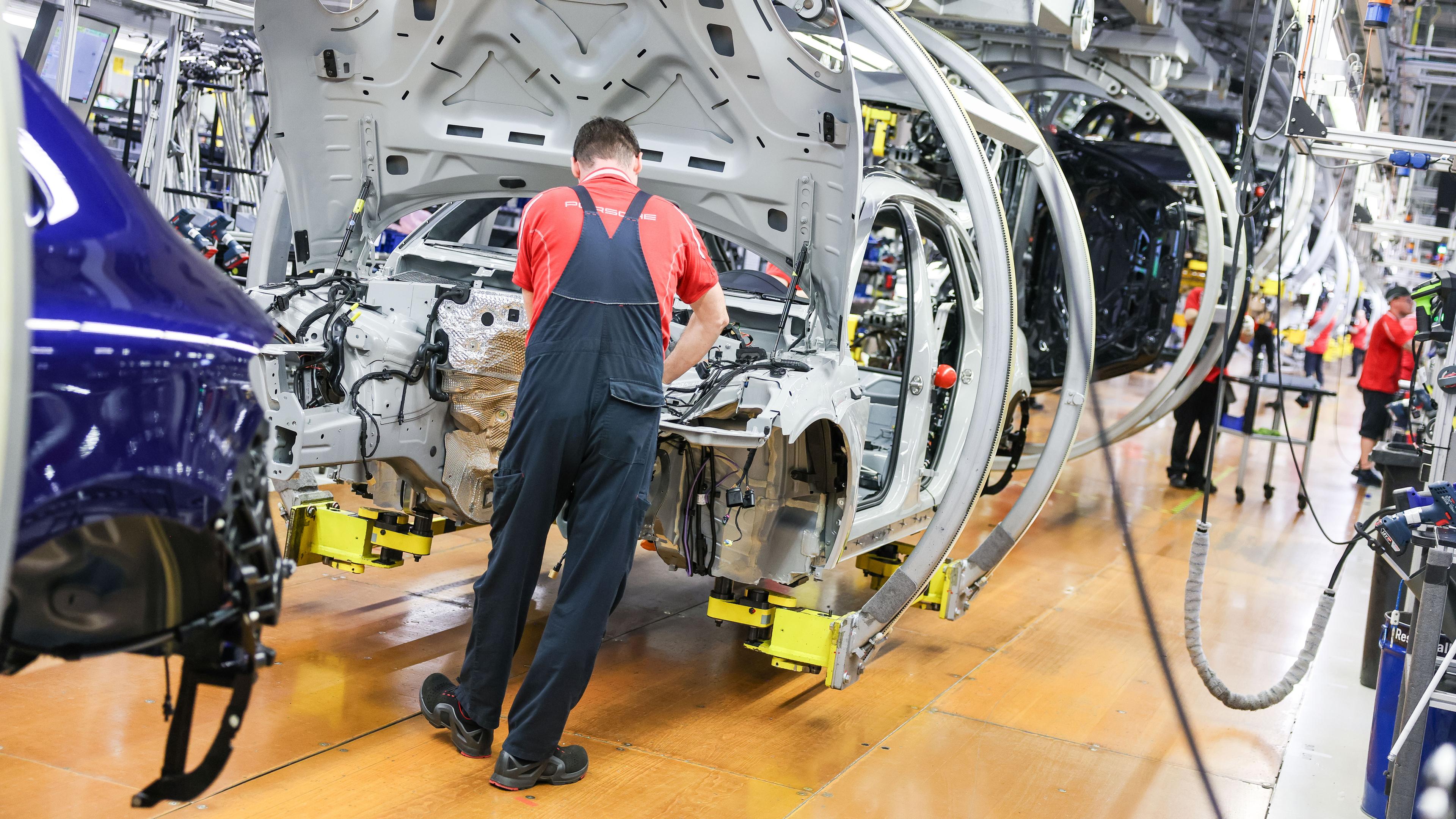 Symbolbild: Ein Mitarbeiter montiert einen Porsche Macan im Werk Leipzig. 