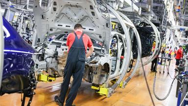 Symbolbild: Ein Mitarbeiter montiert einen Porsche Macan im Werk Leipzig. 
