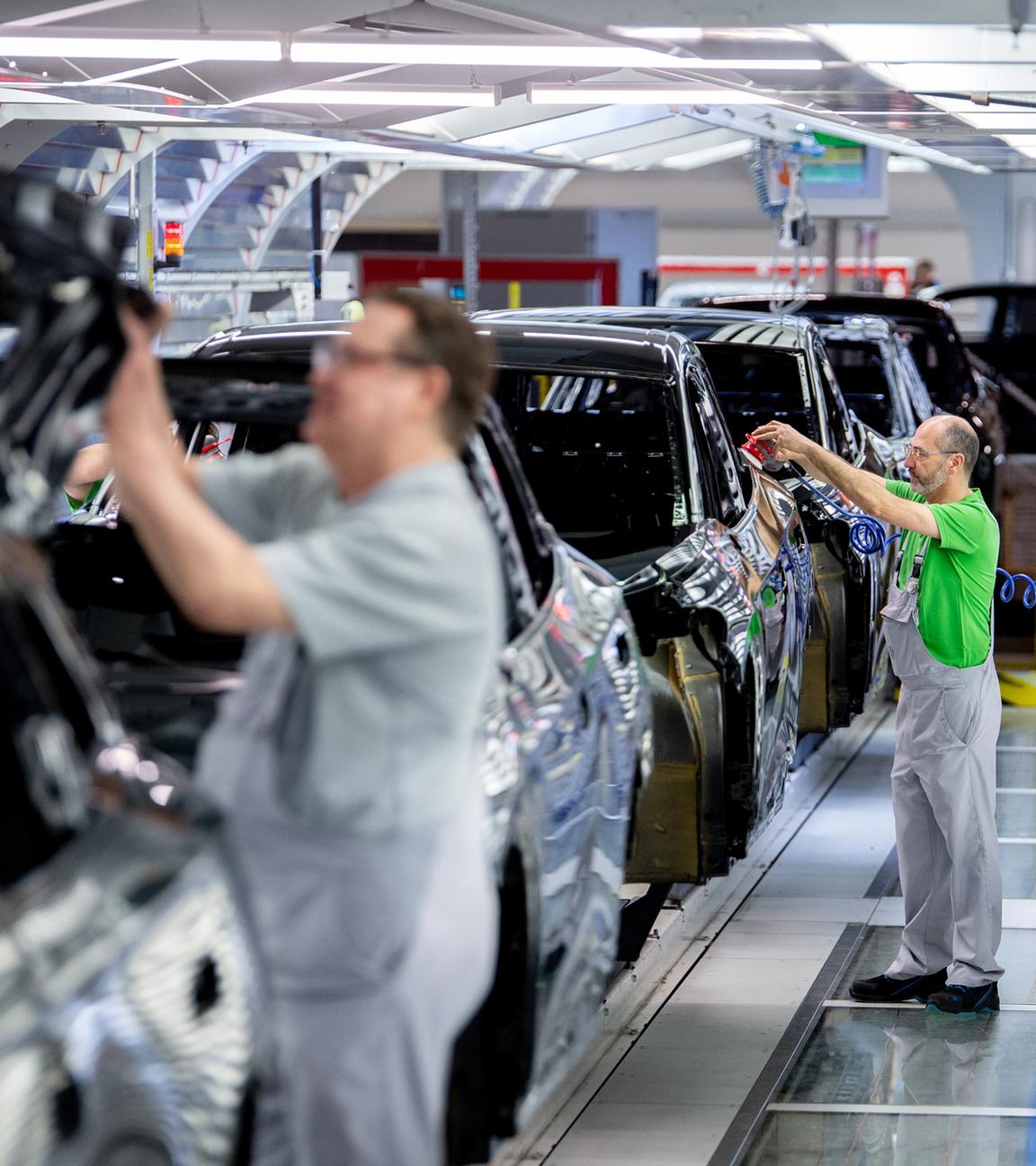 Mitarbeiter überprüfen im Lichttunnel der Lackiererei im Werk von Volkswagen den Lack einer Karosserie am 24.02.2026 in Emden. 