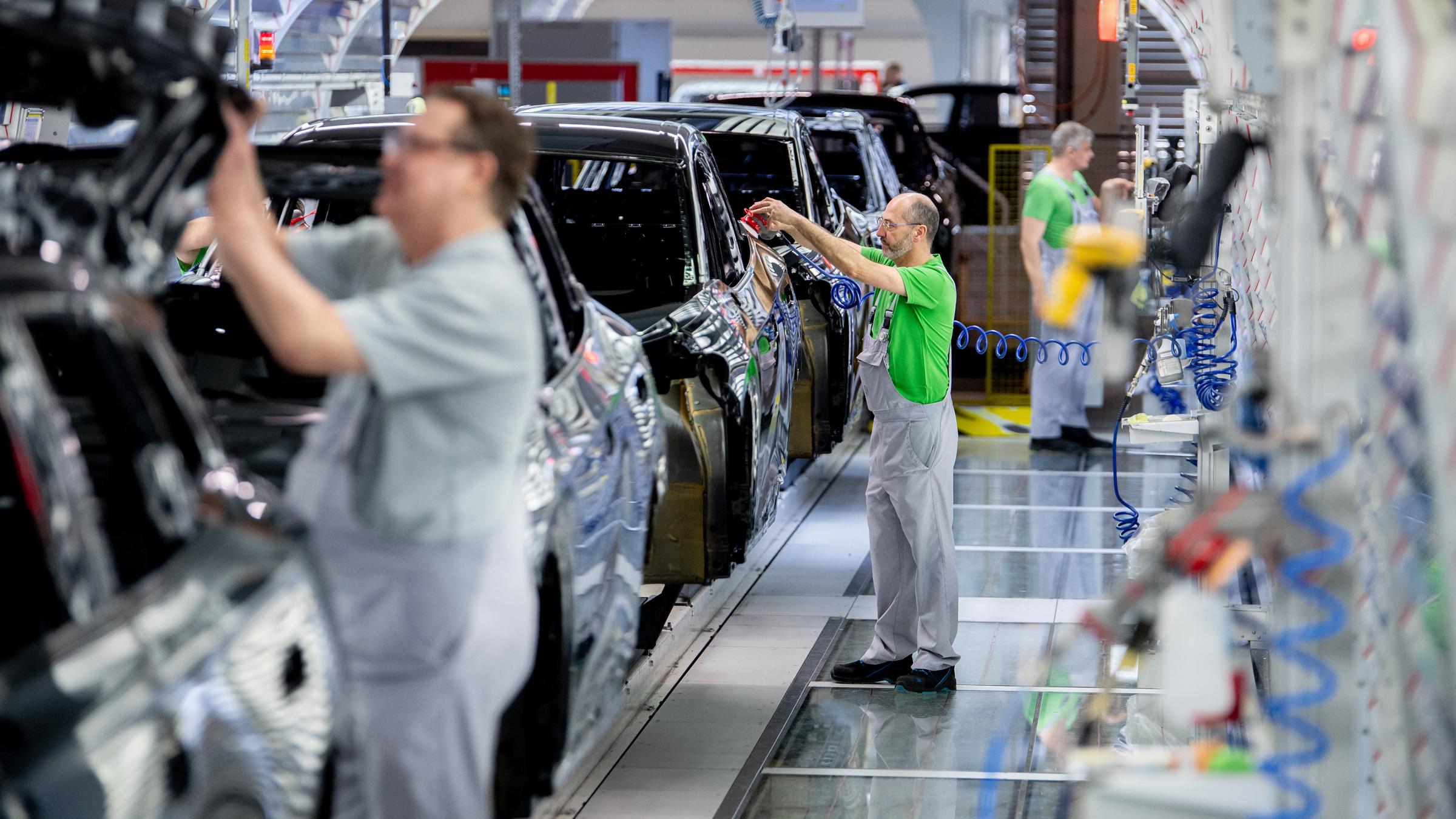 Mitarbeiter überprüfen im Lichttunnel der Lackiererei im Werk von Volkswagen den Lack einer Karosserie am 24.02.2026 in Emden. 