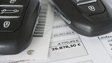 Autokaufvertrag mit Autoschlüssel in Nahaufnahme