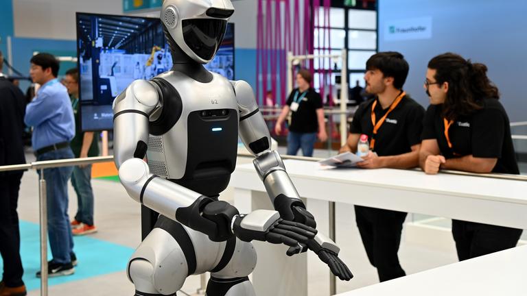 Ein Roboter steht an einem Messestand.