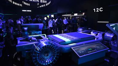 Bei einer Automesse in Shanghai stehen Menschen um ein Modell einer Autobatterie herum