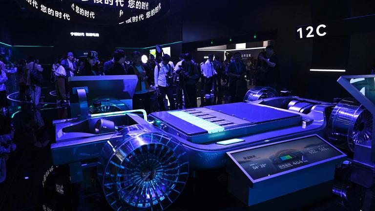 Bei einer Automesse in Shanghai stehen Menschen um ein Modell einer Autobatterie herum