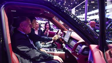 Menschen testen die technischen Möglichkeiten eines chinesischen Elektroautos.