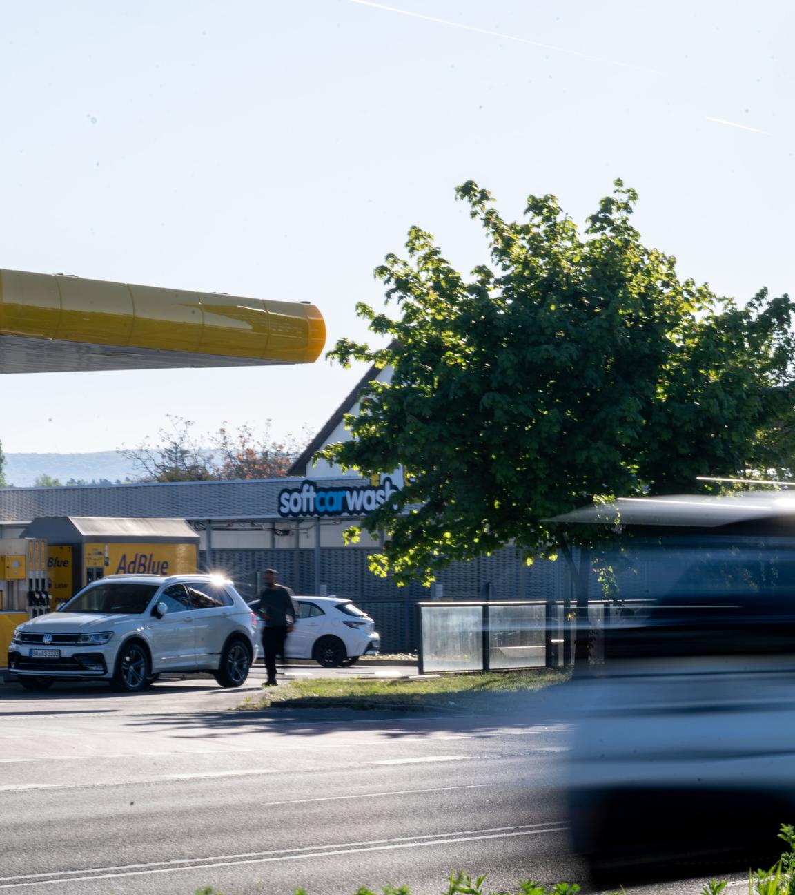 An einer Tankstelle in Bamberg stehen am 01.05.2026 Autos zum Tanken an, während ein weiteres Fahrzeug auf einer Straße davor bei bestem Ausflugswetter vorbeifährt.