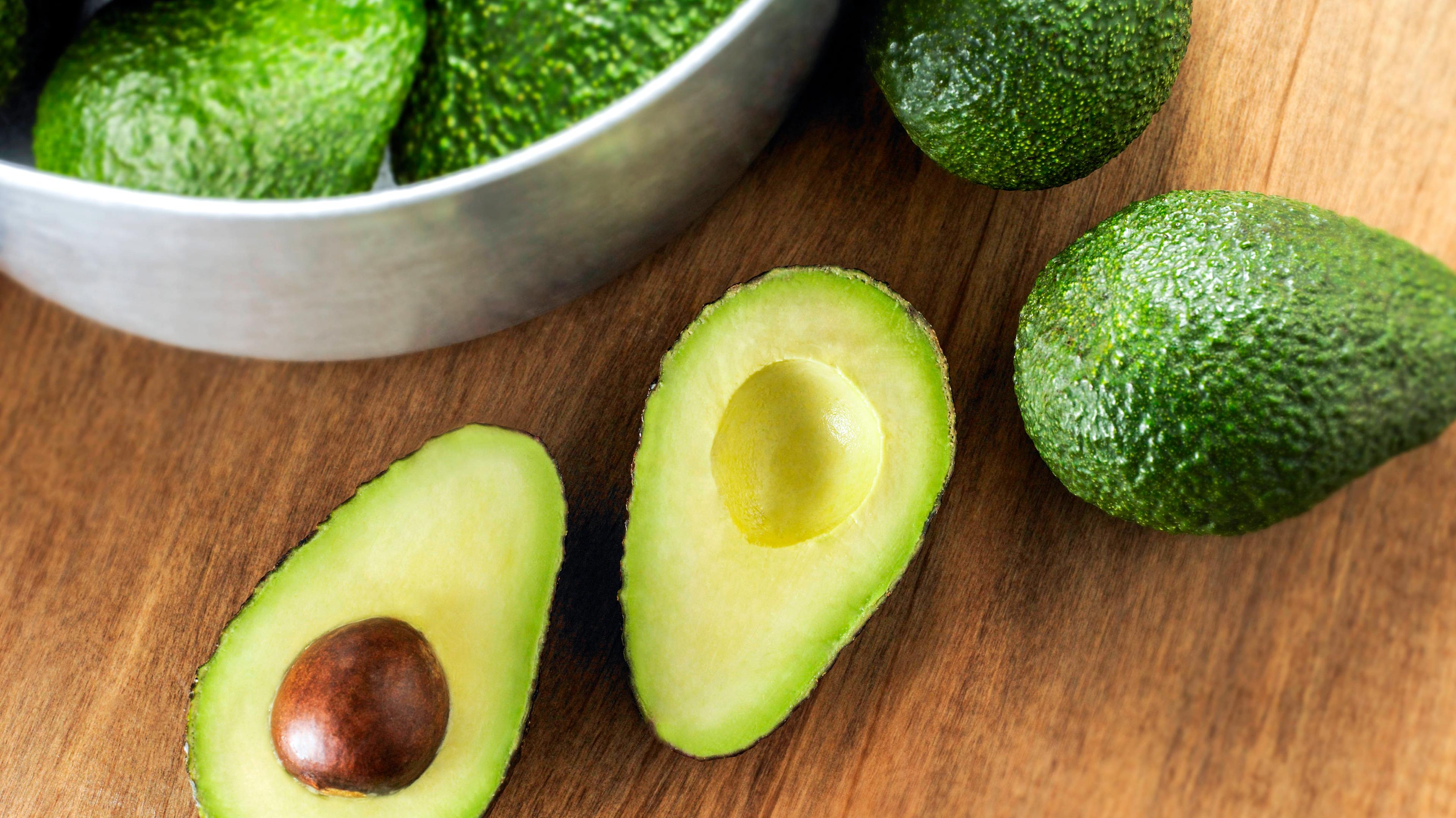 Avocados liegen auf einem Tisch.