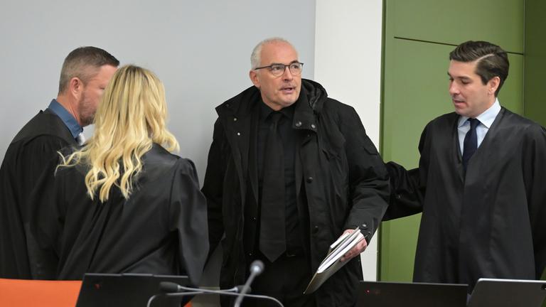 Der Ex-CDU-Abgeordnete Axel Fischer betritt vor Prozessbeginn wegen Bestechlichkeitsvorwürfen in der Aserbaidschan-Affäre den Gerichtssaal des OLG Karlsruhe, begleitet von seinen Anwälten.