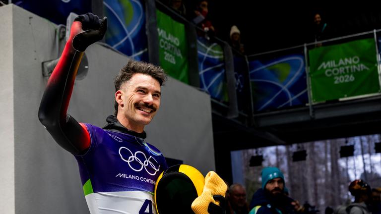 Axel Jungk jubelt im Ziel beim Skeleton-Rennen der Männer am 12.02.2026 in Cortina d'Ampezzo.