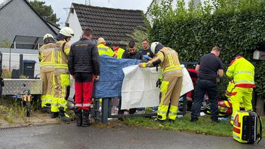 Auf dem Bild zu sehen: Viele Einsatzkräfte stehen an einem Grundstück.