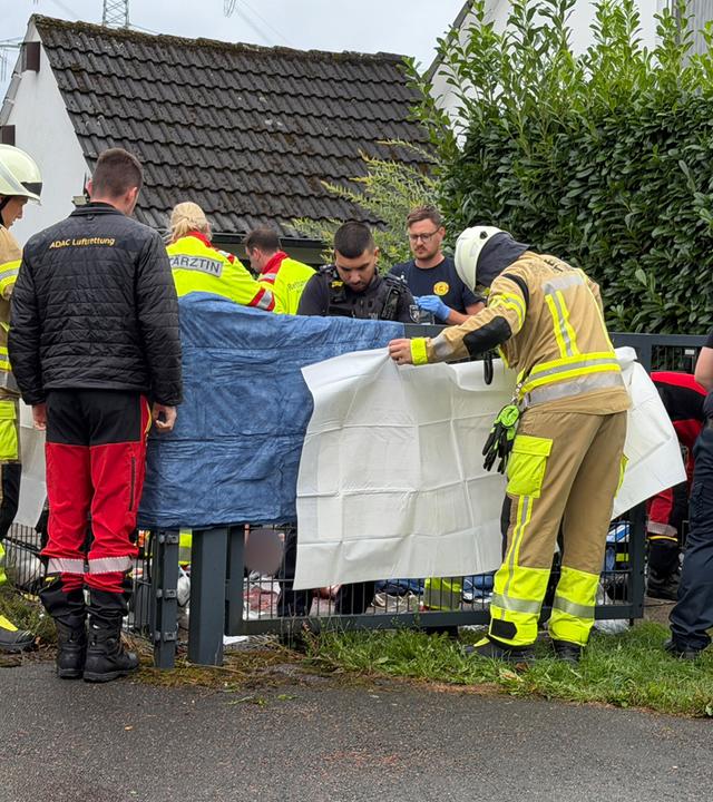 Auf dem Bild zu sehen: Viele Einsatzkräfte stehen an einem Grundstück.