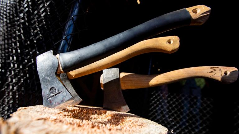 Drei Äxte stecken in einem Baumstumpf