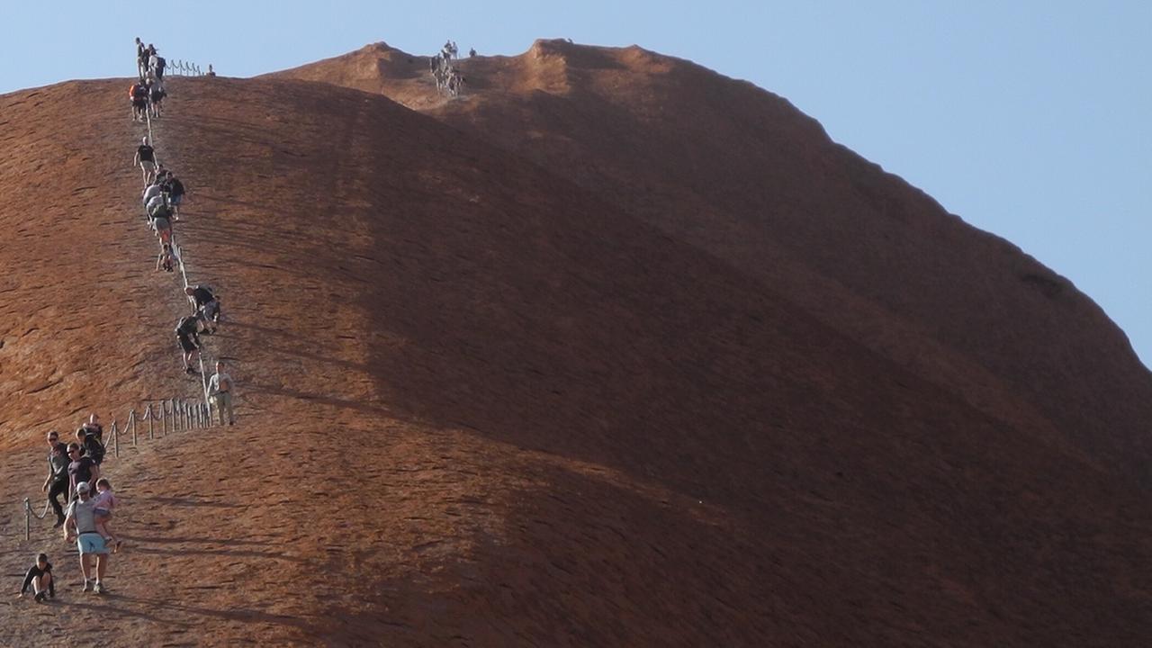 Eine Reihe von Menschen steigt den Berg hinauf