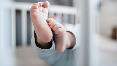 Baby in Gitterbett