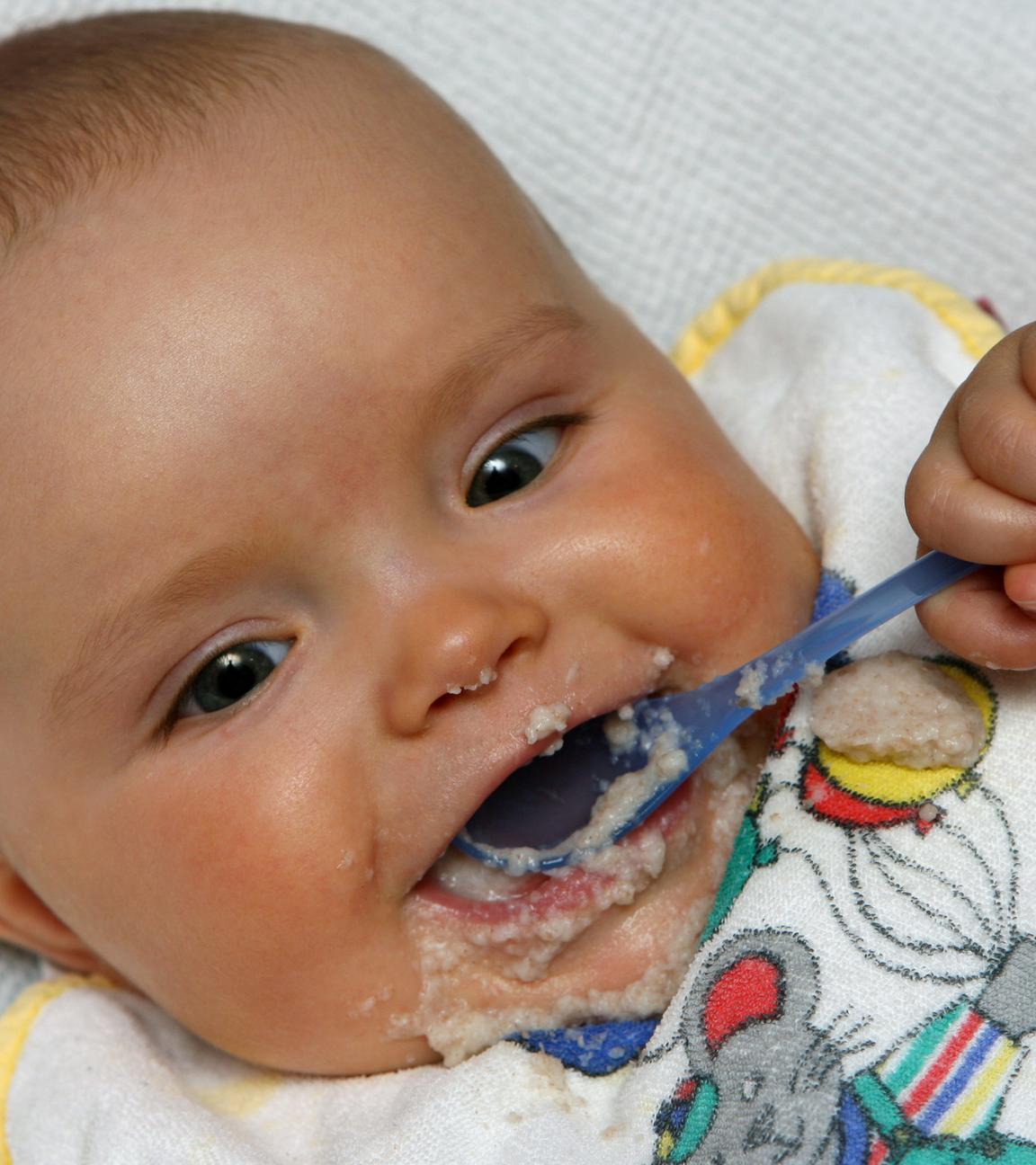 Baby mit Löffel im Mund