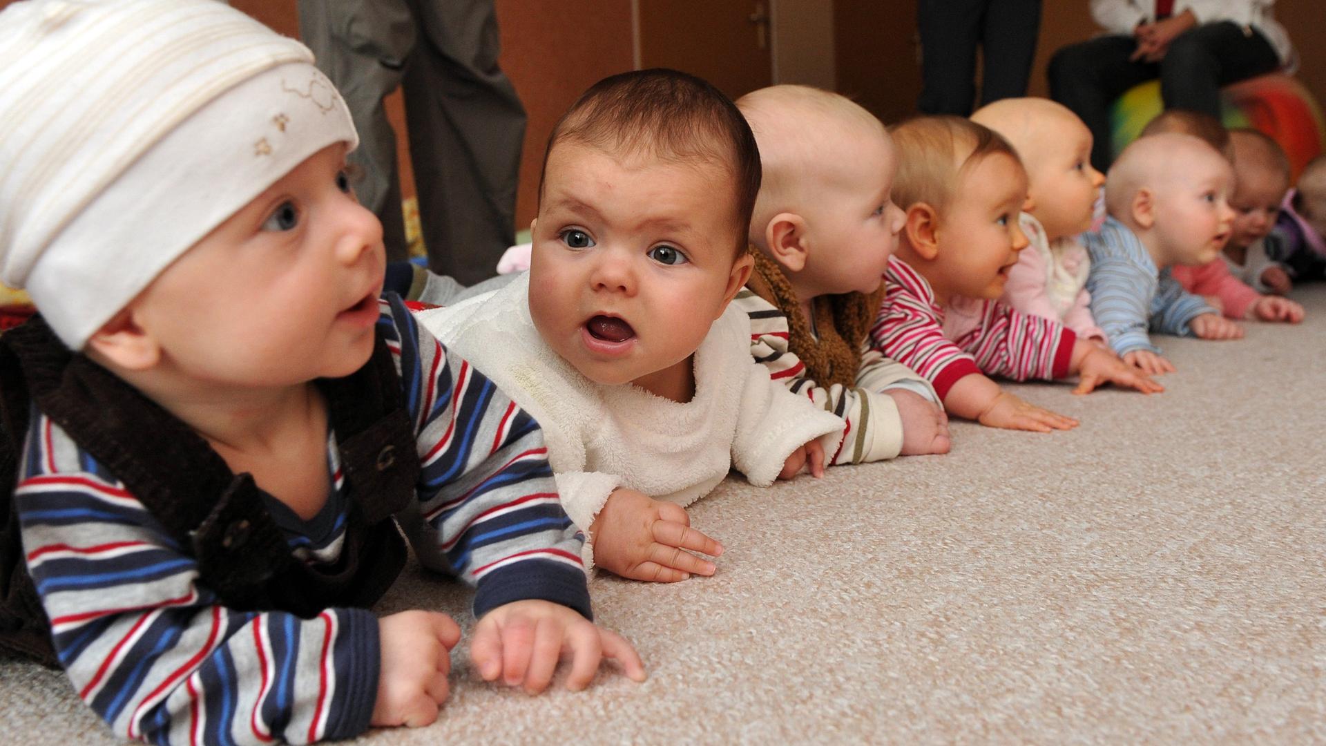 Babys liegen nebeneinander auf dem Bauch