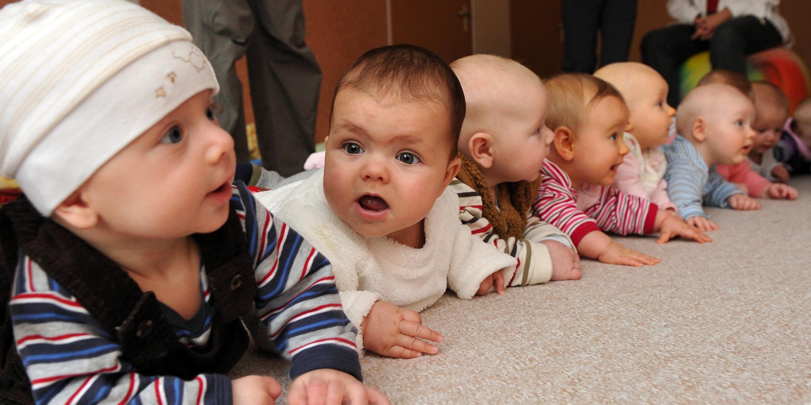 Babys liegen nebeneinander auf dem Bauch