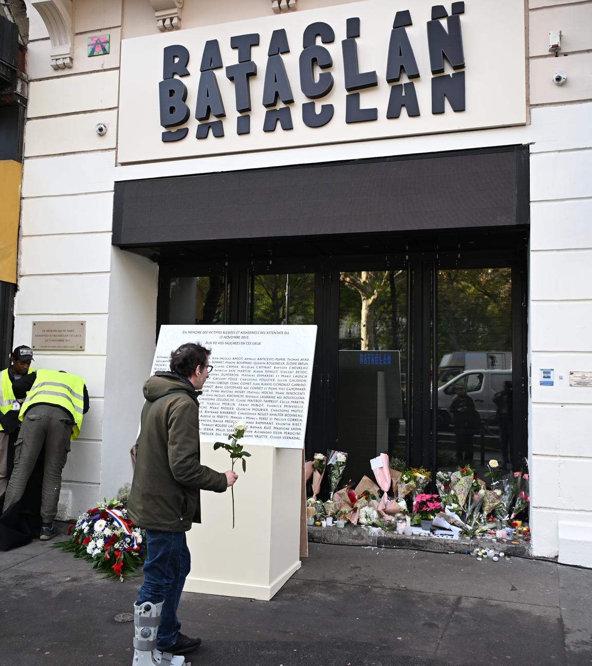 Man erkennt einen Mann der vor dem Bacatlan eine weiße Rose hält