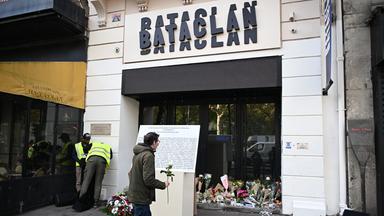Man erkennt einen Mann der vor dem Bacatlan eine weiße Rose hält