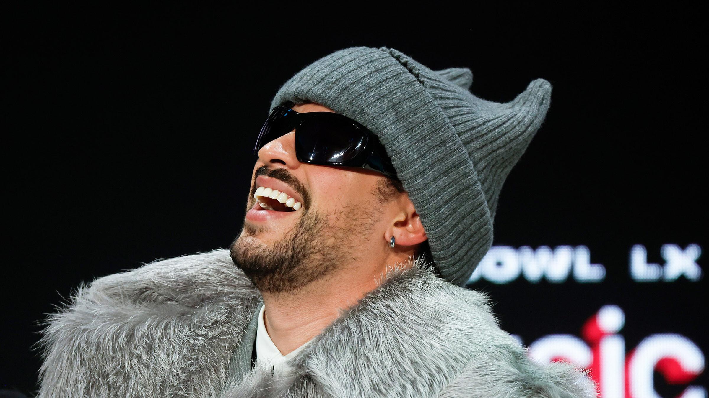 Bad Bunny lacht für die Kamera. 