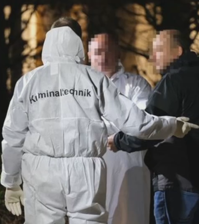 Spurensicherung arbeitet vor Klinik, Mann in weißem Schutzanzug mit Aufdruck "Polizei"- Nachtbilder