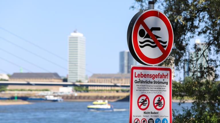 Ein Schild am Ufer des Rheins warnt vor dem Schwimmen und Baden im Fluss.