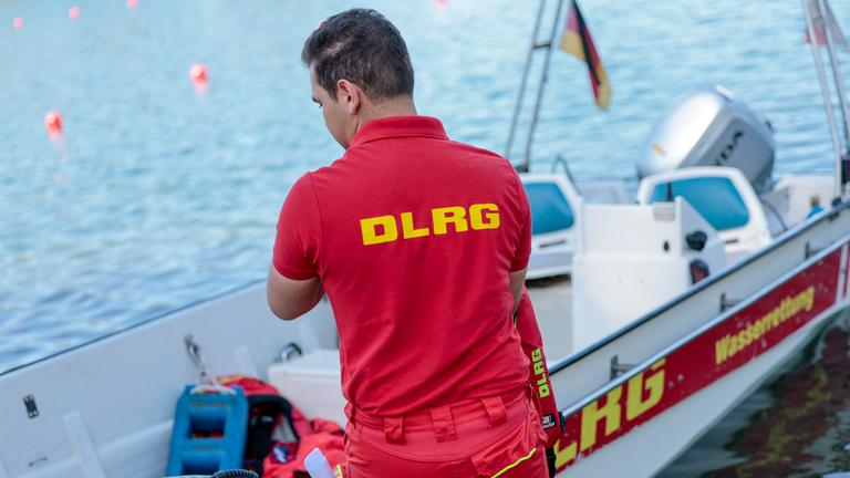 25.06.2025, Nordrhein-Westfalen, Köln: Einsatzkräfte der Berufsfeuerwehr Köln, der DLRG (Deutsche Lebens-Rettungs-Gesellschaft) und von den Rettungstauchern (Wasserrettung) simulieren die Rettung einer Person aus dem Fühlinger See