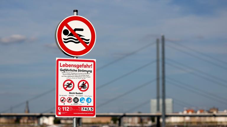 Lebensgefahr: Ein Schild am Paradiesstrand in Düsseldorf warnt vor gefährlicher Strömung und Lebensgefahr beim Baden im Rhein. 