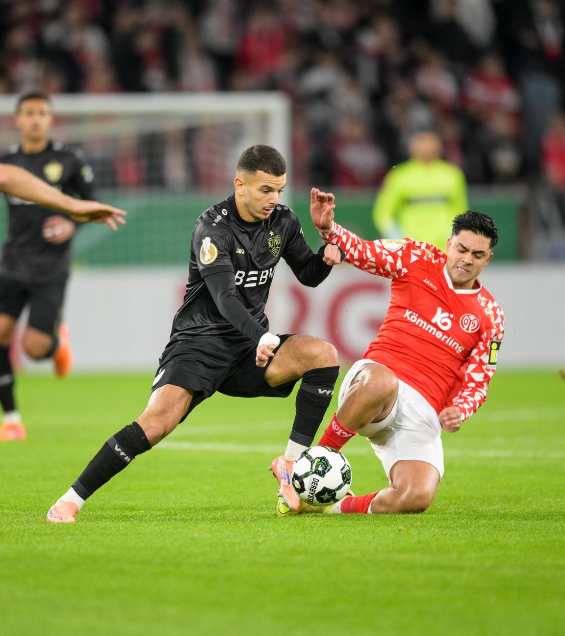 Fußballer Badredine Bouanani (Suttgart, 27, von links) und Nadiem Amiri (Mainz, 10) im rechten Bildbereich im Zweikampf um den Ball im Mainzer Stadio MEWA Arena.