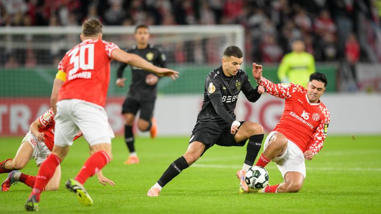 Fußballer Badredine Bouanani (Suttgart, 27, von links) und Nadiem Amiri (Mainz, 10) im rechten Bildbereich im Zweikampf um den Ball im Mainzer Stadio MEWA Arena.