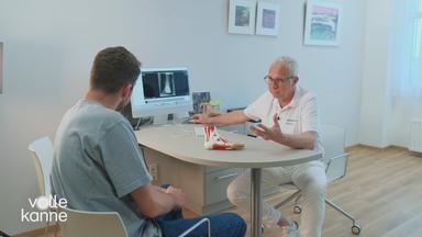 Arzt und Patient schauen sich Röntgenbilder an 