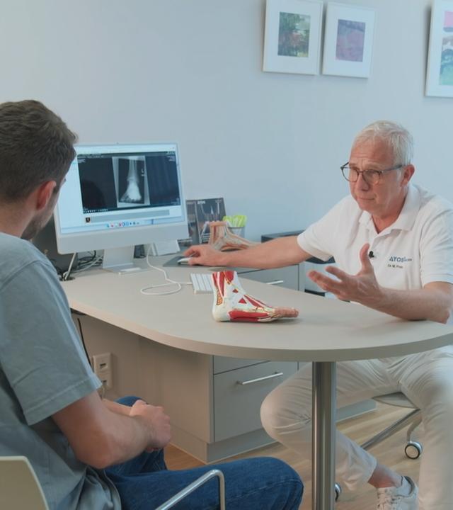 Arzt und Patient schauen sich Röntgenbilder an 