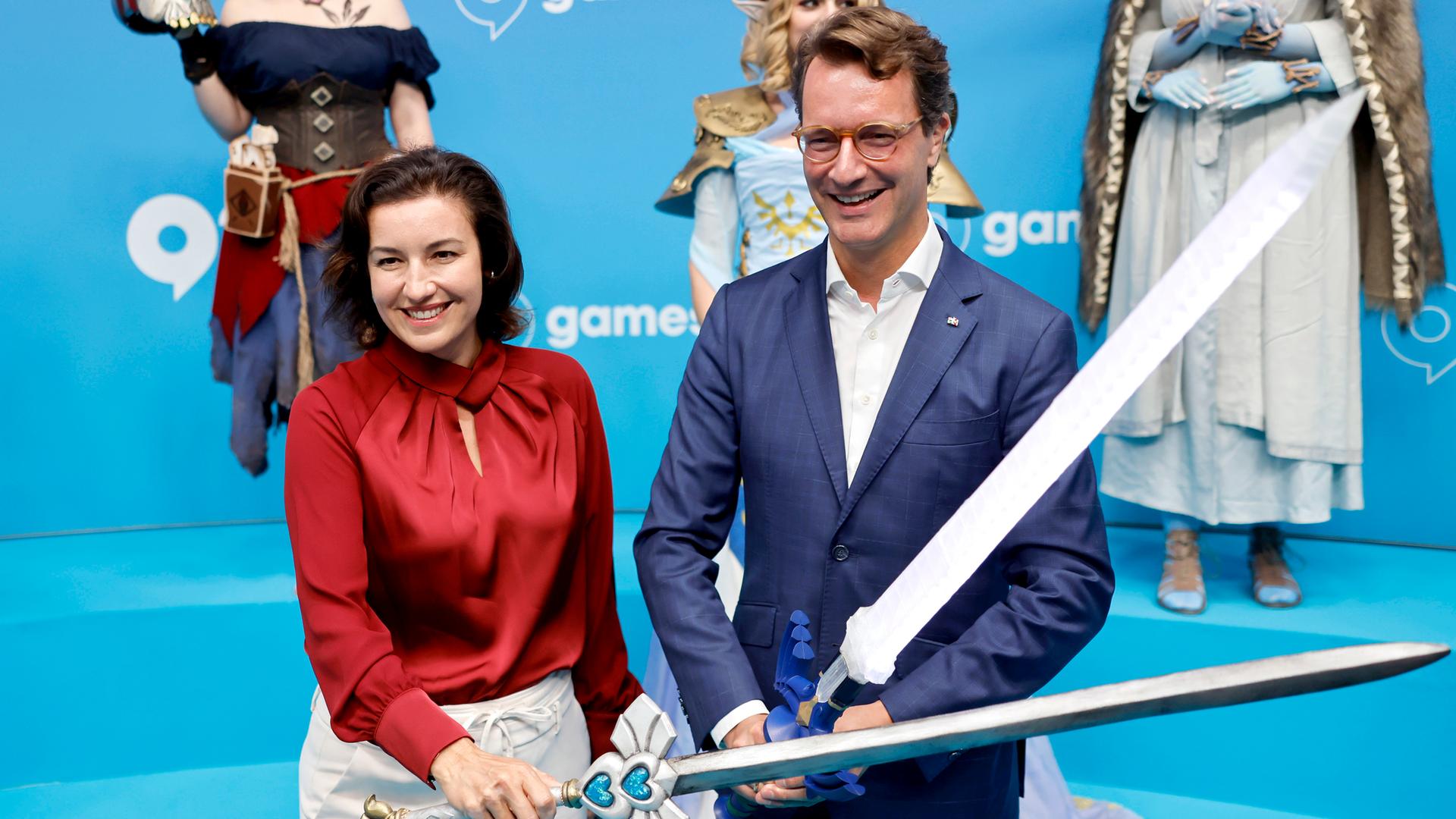 NRW-Ministerpräsident Hendrik Wüst (CDU) und Bundesforschungsministerin Dorothee Bär (CSU) kreuzen Schwerter von Cosplayern