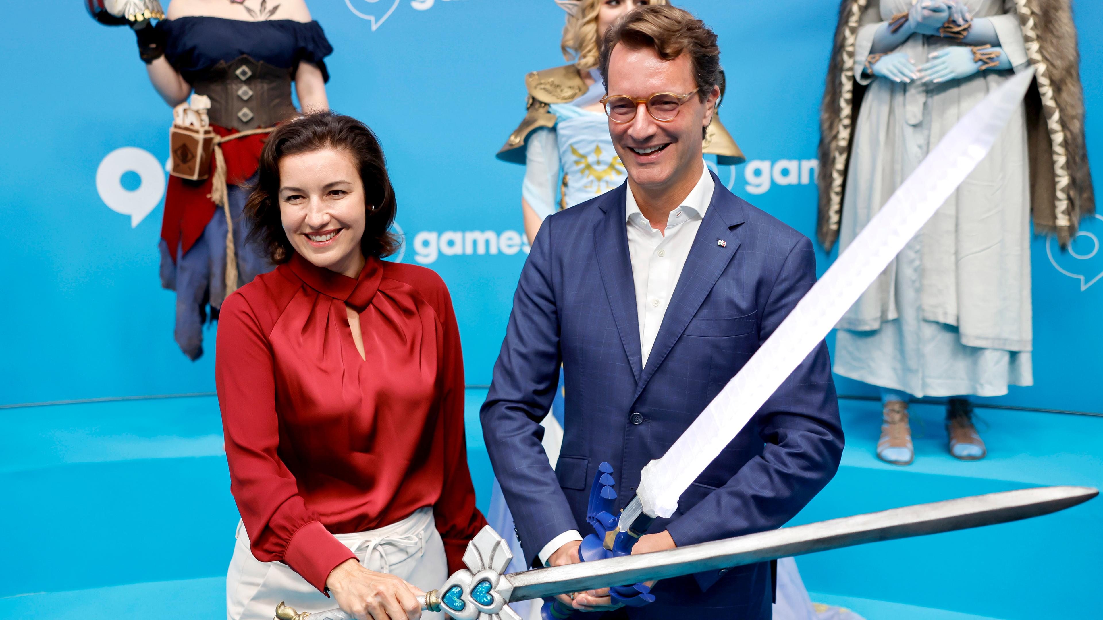 NRW-Ministerpräsident Hendrik Wüst (CDU) und Bundesforschungsministerin Dorothee Bär (CSU) kreuzen Schwerter von Cosplayern